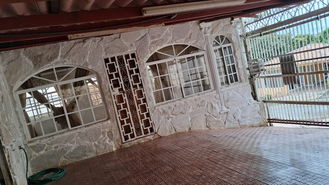 Terraza cubierta con pared de piedra y ventanales arqueados — casa en Altamira, Arraiján